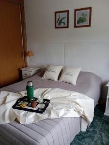 een bed met een dienblad met eten erop bij AppartMaipu496 in Balcarce