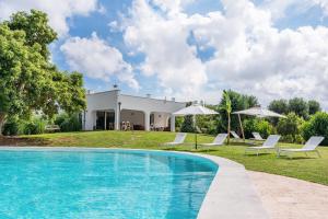 una villa con piscina di fronte a una casa di Villa Clive Relax & Sun a Ostuni