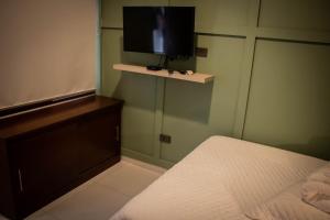 a bedroom with a bed and a flat screen tv at La Casona in Santa Cruz de la Sierra