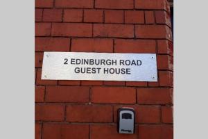 a sign for a guest house on a brick wall at Liverpool city 5 bed house sleeps 12 in Liverpool