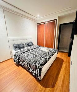 a bedroom with a bed and a wooden floor at Villa bella californie in Casablanca