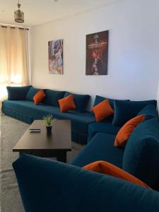 a living room with blue couches and a table at Villa bella californie in Casablanca