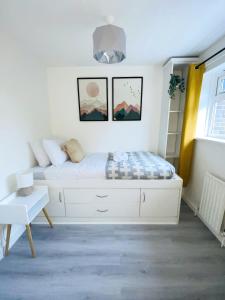 um quarto com uma cama branca e uma janela em Home in Farnborough with Free Parking, Wifi & Netflix em Farnborough