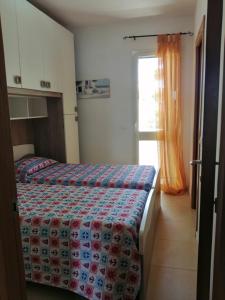 - une chambre avec 2 lits et une fenêtre dans l'établissement Case in Residence Torre dell'Orso, à Torre dell'Orso
