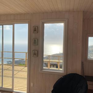 a room with two windows and a view of the ocean at Mar&cielo in Zapallar