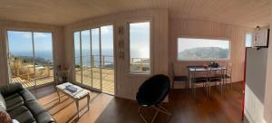 a living room with a couch and a table and windows at Mar&cielo in Zapallar