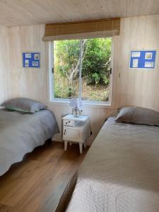 2 camas en una habitación pequeña con ventana en Mar&cielo, en Zapallar