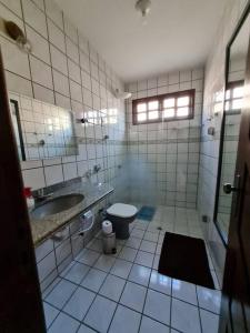 a bathroom with a sink and a toilet at Casa agradável: piscina, churrasqueira e redário. in Natal
