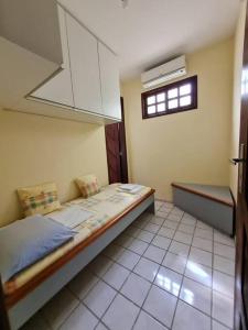 a small bedroom with a bed and a window at Casa agradável: piscina, churrasqueira e redário. in Natal