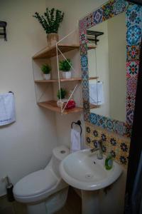 een badkamer met een toilet, een wastafel en een spiegel bij DEPARTAMENTO DE LUJO AJIJIC in Jocotepec