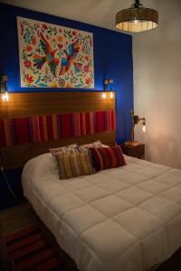 een slaapkamer met een groot bed en een schilderij aan de muur bij DEPARTAMENTO DE LUJO AJIJIC in Jocotepec