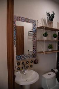 een badkamer met een wastafel, een toilet en een spiegel bij DEPARTAMENTO DE LUJO AJIJIC in Jocotepec