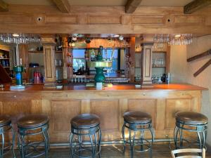 un bar con taburetes en una habitación con barra en The Lunablu Lodge Sunday River, en Bethel