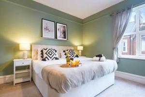 a bedroom with a bed with a tray of fruit on it at Central House with Parking, Pool Table, Super-Fast Wifi and Smart TV with Virgin Media and Netflix by Yoko Property in Northampton