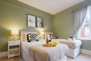 two beds in a room with green walls at Central House with Parking, Pool Table, Super-Fast Wifi and Smart TV with Virgin Media and Netflix by Yoko Property in Northampton