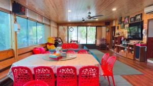 東勢區的住宿－82山莊包棟住宿-台中東勢-山景花園，一间带桌子和红色椅子的用餐室