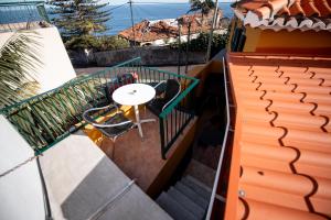 - un balcon avec une table et des chaises dans un bâtiment dans l'établissement Casa das Vistas, à Porto Moniz