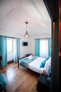- une chambre avec un grand lit et des rideaux bleus dans l'établissement Casa das Vistas, à Porto Moniz