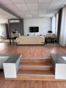 a living room with a couch and a flat screen tv at Loft Exclusif 100m2 in Grimbergen