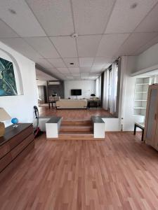 a large room with wooden floors and a room with a couch at Loft Exclusif 100m2 in Grimbergen