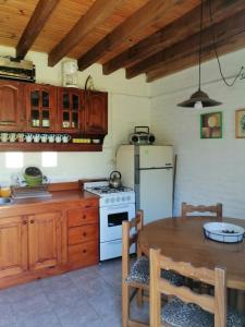 een keuken met een tafel, een fornuis en een koelkast bij ROMFER II in San Eduardo del Mar