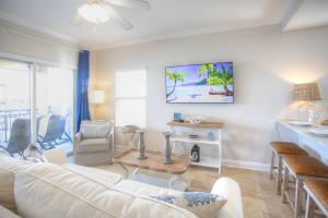 ein Wohnzimmer mit einem weißen Sofa und Stühlen in der Unterkunft Palms of Treasure Island Resort in St Pete Beach