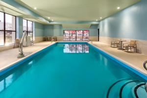 a swimming pool with blue water in a building at Holiday Inn Express - New Albany in New Albany