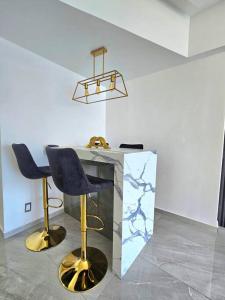 Pokój z 2 krzesłami i marmurowym biurkiem w obiekcie departamento con vista al mar w Acapulco