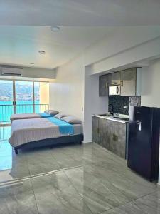 departamento con vista al mar في أكابولكو: غرفة نوم بسرير كبير ومطبخ