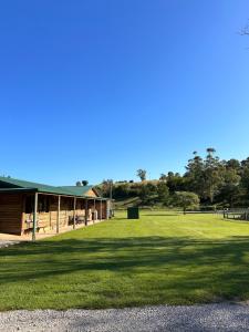 a building with a large field of grass in front of it at The River Retreat Buchan in Buchan