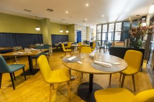 里瓦德奧的住宿－HOTEL JAVIER MONTERO，用餐室配有桌子和黄色椅子