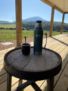 uma garrafa térmica e uma chávena numa mesa de madeira num alpendre em La Aristobula em Piriápolis