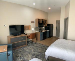 a hotel room with a bed and a flat screen tv at Candlewood Suites Oklahoma City-Moore, an IHG Hotel in Moore