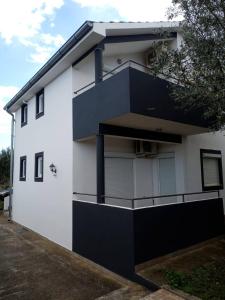 a black and white building with a balcony at Apartments with a parking space Kraj, Pasman - 8213 in Tkon