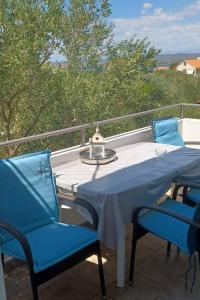 a table and two chairs on a balcony with a table and chairs at Apartments with a parking space Kraj, Pasman - 8213 in Tkon