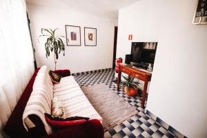 een woonkamer met een bank en een televisie bij Casa da Avo Rosa in São Vicente
