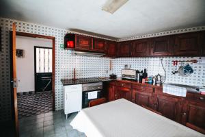 a kitchen with wooden cabinets and a white stove top oven at Casa da Avo Rosa in São Vicente