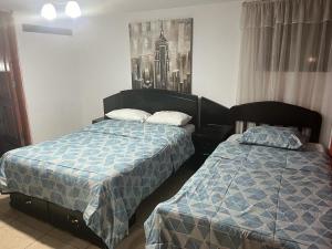 twee bedden naast elkaar in een slaapkamer bij HOTEL SAN VICENTE in Cajamarca