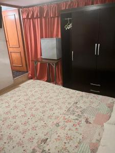 um quarto com uma cama, uma mesa e um armário em HOTEL SAN VICENTE em Cajamarca