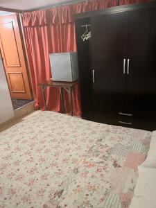 um quarto com uma cama, uma mesa e um armário em HOTEL SAN VICENTE em Cajamarca