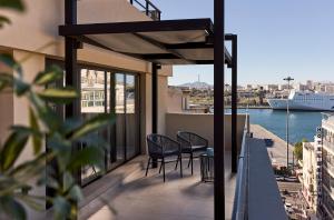 a balcony with chairs and a view of a ship at Athenarum Portus Life & Style Hotel in Piraeus