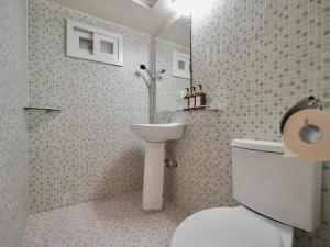 a bathroom with a white toilet and a sink at J5 Hostel in Seoul