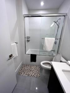 y baño blanco con ducha y aseo. en Grand Boulevard Guest Suite, en North Vancouver