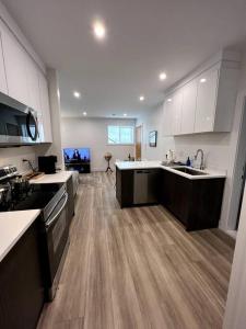 cocina grande con suelo de madera y armarios blancos en Grand Boulevard Guest Suite, en North Vancouver