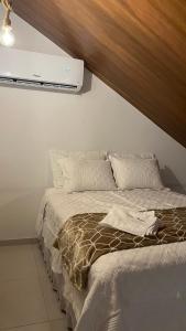 sypialnia z łóżkiem z telewizorem na ścianie w obiekcie Villa Suíça, Chalé Mezanino w mieście Tianguá