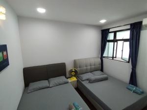 a bedroom with two beds and a window at Skyloft Premium Suites 8 pax in Johor Bahru