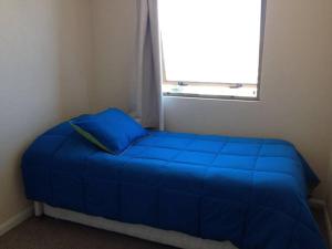 una cama azul en una habitación con ventana en Miramar, en Viña del Mar 6 fotos más