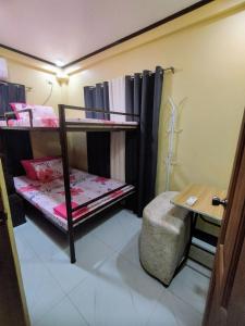 a room with two bunk beds and a table at Jumong's Transient Inn in Bantay