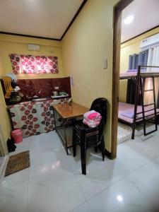 a room with a table and a room with bunk beds at Jumong's Transient Inn in Bantay