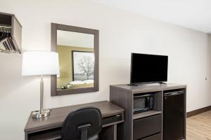 a room with a television and a desk with a chair at Super 8 by Wyndham Johnson City in Johnson City